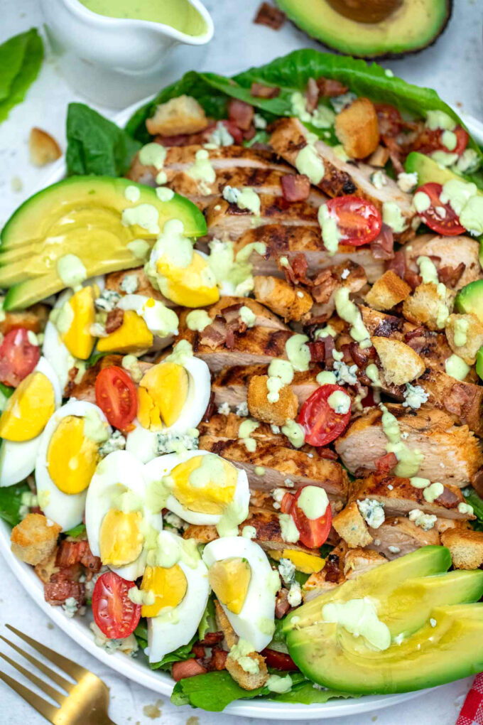 Easy Cobb salad with grilled chicken and avocado on a white plate.