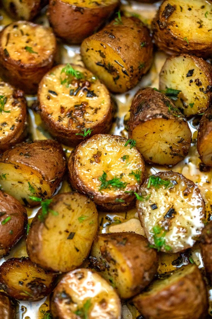 Picture of oven roasted baby red potatoes with on a baking dish.