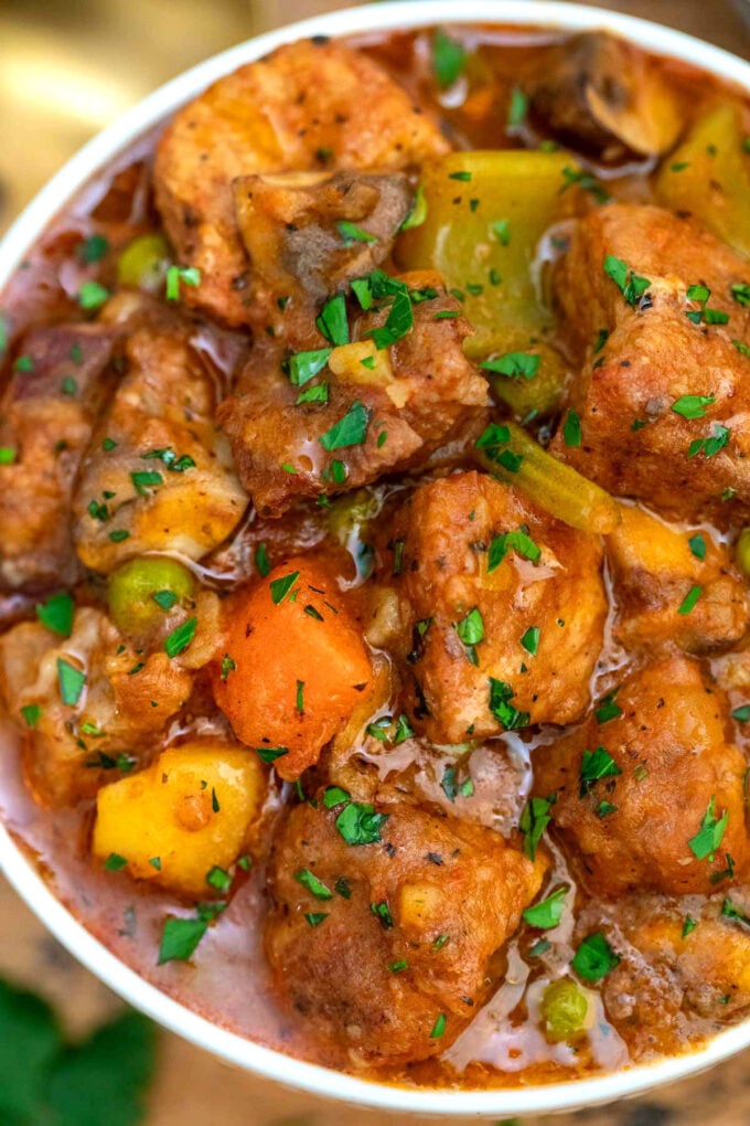 a bowl of pork stew with potatoes and carrots.