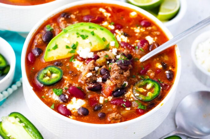 Instant Pot taco soup topped with sliced avocado and jalapenos.