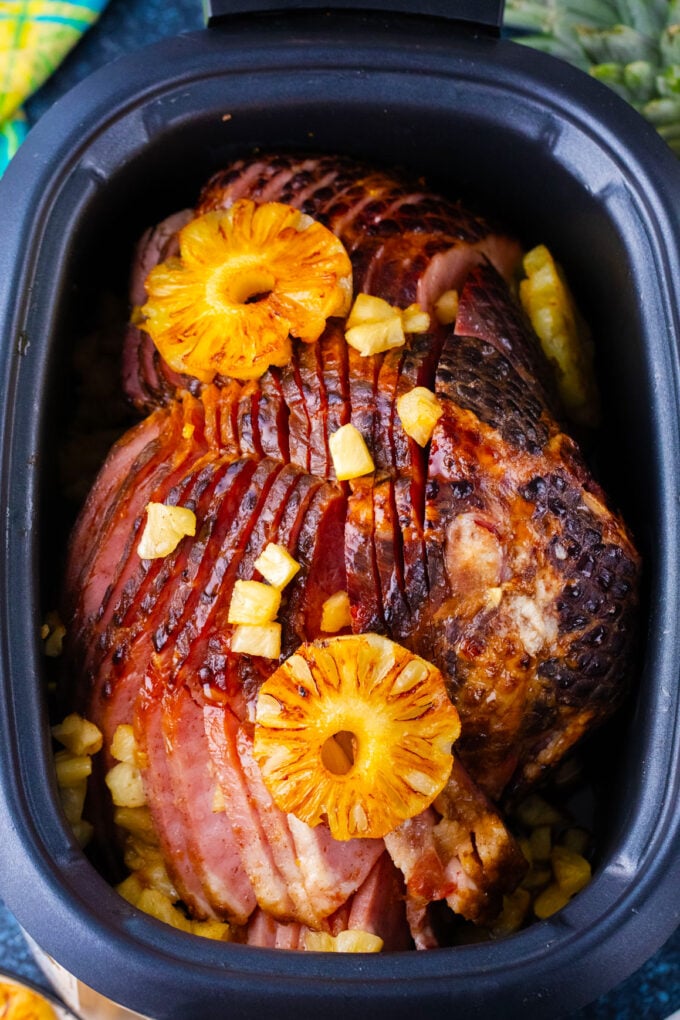 Overhead shot of homemade slow cooker pineapple ham topped with pineapple pieces.