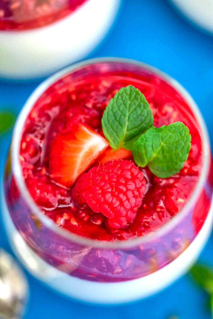 Image of Panna Cotta topped with raspberry sauce and mint leaves.