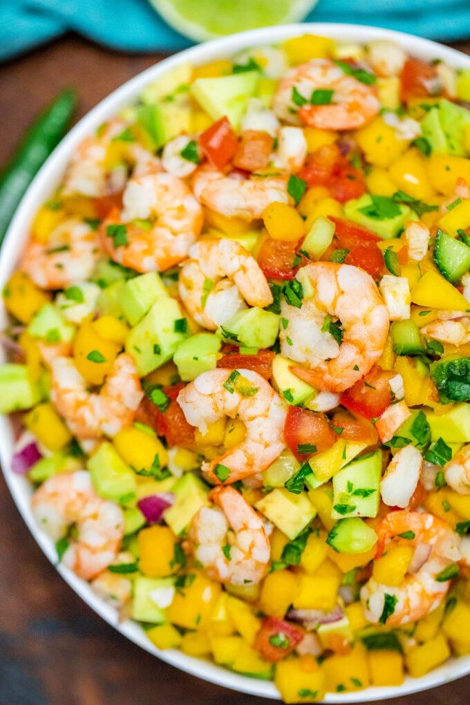 A bowl of shrimp ceviche with mango, tomatoes, and avocado.