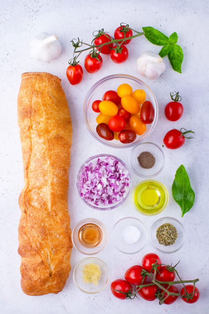 Overhead shot of Italian tomato bruschetta ingredients in bowls.