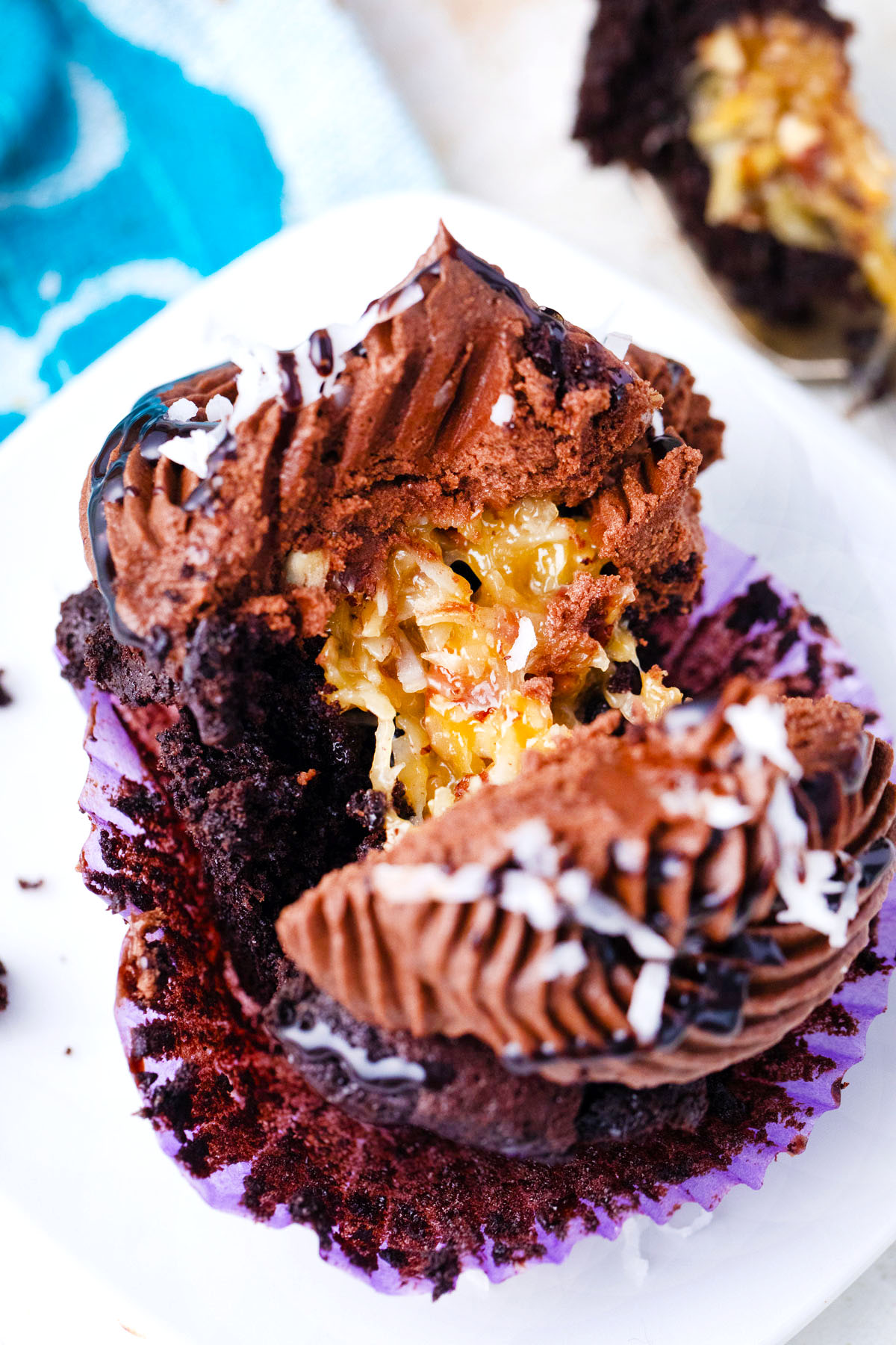 Sliced German chocolate cupcake revealing coconut-pecan filling.