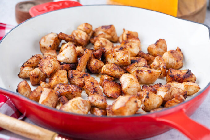 Cooking chicken pieces in a skillet.