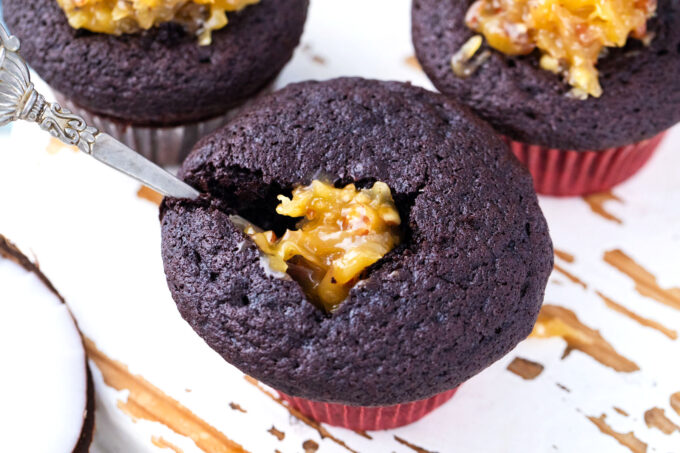 Filling chocolate cupcakes with coconut-pecan filling.