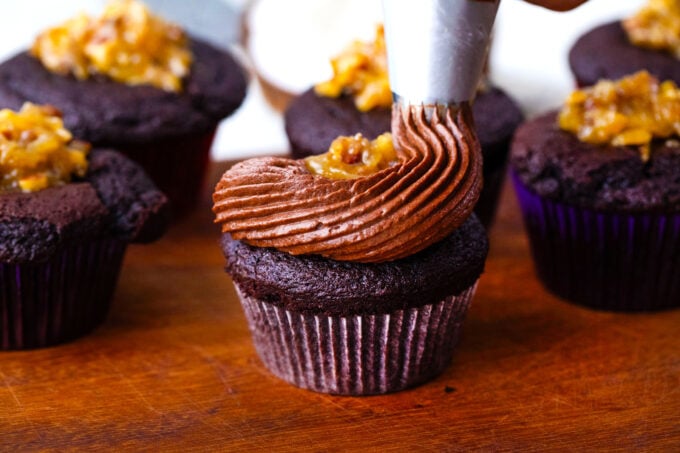 Topping German chocolate cupcakes with chocolate batter.