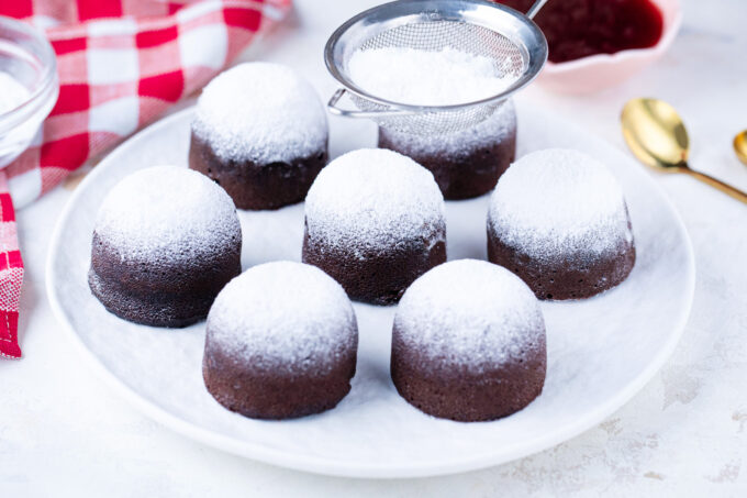 Dusting instant pot chocolate muffins with powdered sugar.
