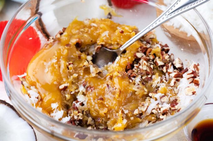 Mixing coconut-pecan fillin in a bowl.