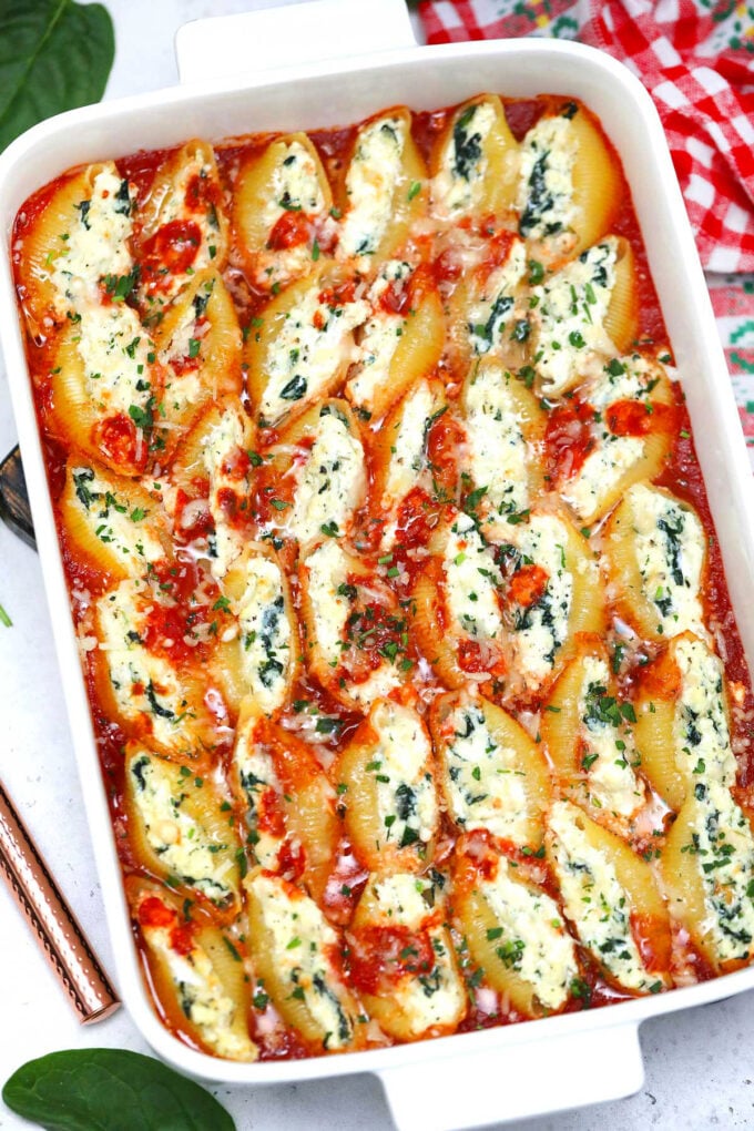 A freshly baked casserole made with stuffed jumbo shells filled with spinach, ricotta cheese, and marinara sauce. 