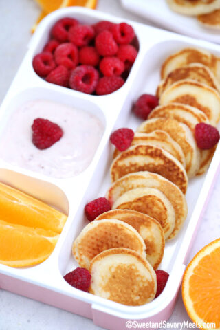 Photo of a lunch box with mini pancakes.