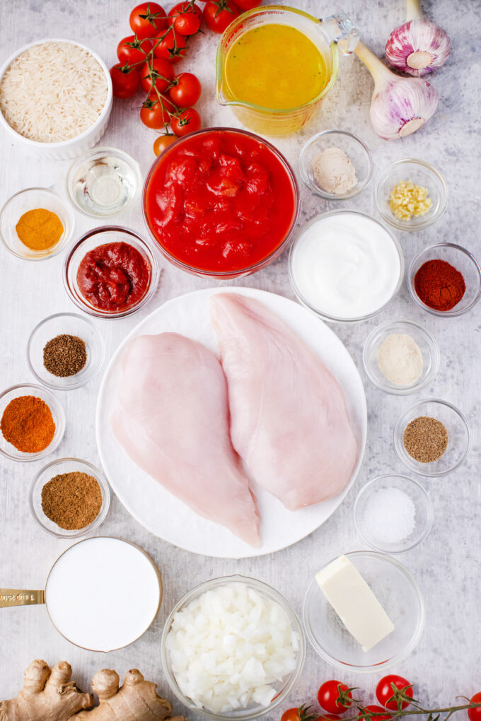 Overhead shot of Instant Pot chicken tikka masala ingredients in bowls on a table.
