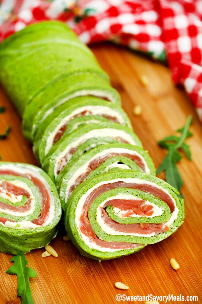 sliced green Keto arugula salmon roll on a cutting board