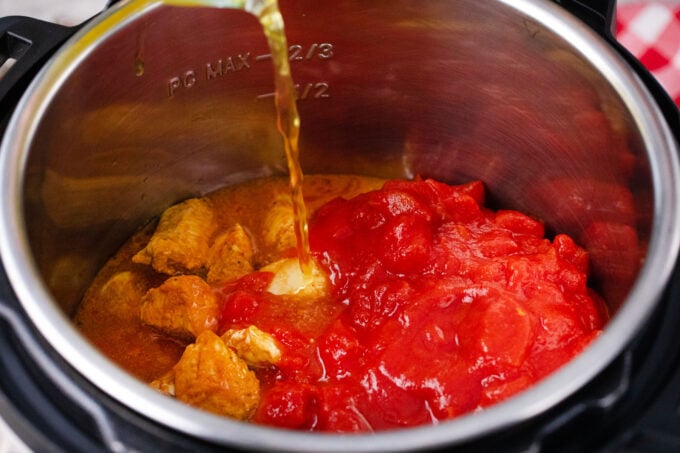Adding chicken tikka masala ingredients to the instant pot.