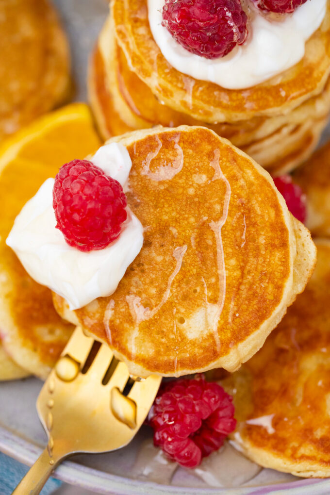 Homemade minu pancakes topped with yogurt and raspberries.