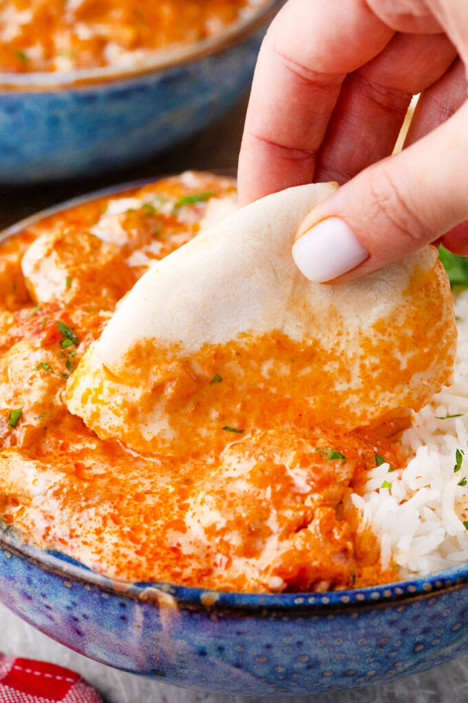 Dipping naan in Instant Pot chicken tikka masala.