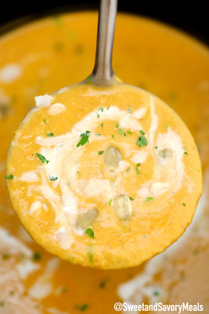 Creamy pumpkin soup topped with roasted pumpkin seeds and chopped parsley