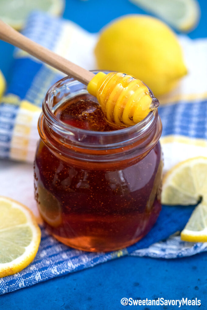 golden syrup in a glass jar with a honey dipper on top