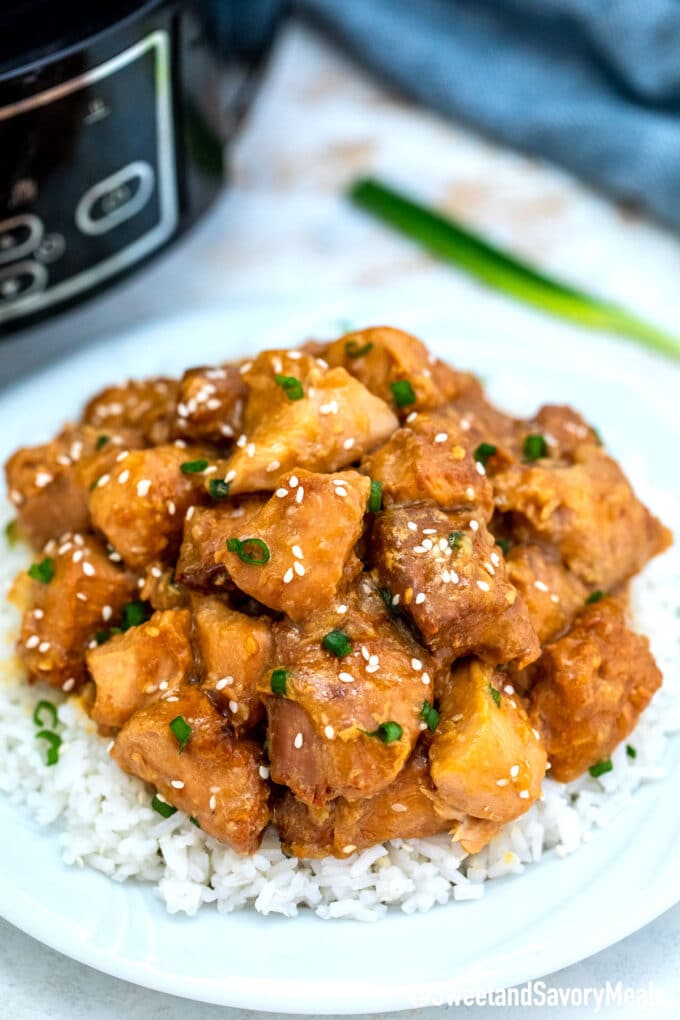 slow cooker sesame chicken over white rice in a plate
