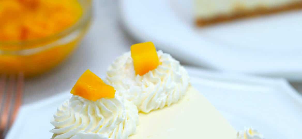 Photo of a slice of no bake mango cheesecake.