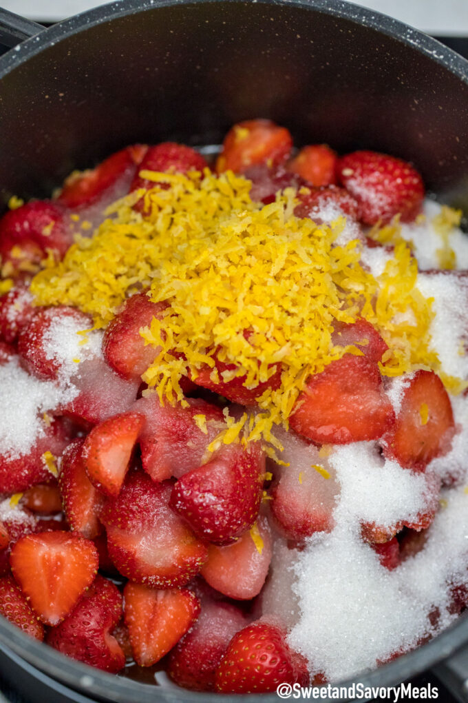 strawberry cobbler filling made of strawberries lemon zest and sugar in a saucepan