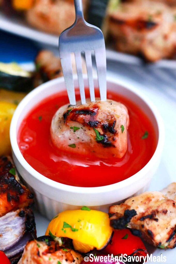 Chicken kabob in red sauce.