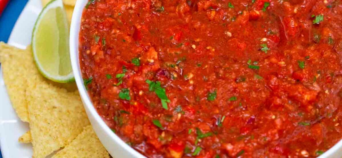 Salsa bowl with chips and lime.