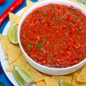 Salsa bowl with chips and lime.