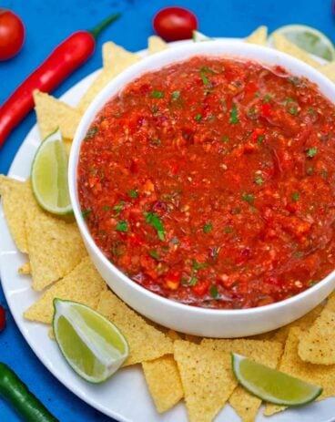 Salsa bowl with chips and lime.
