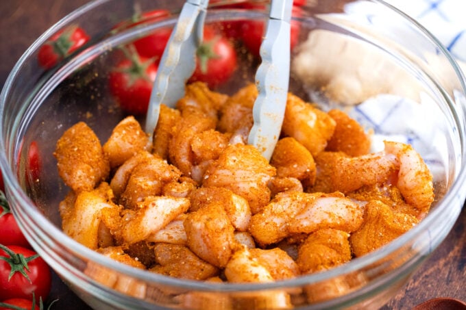 Coating chicken pieces in spices.