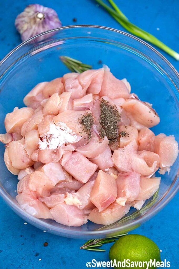 Sliced chicken breasts with seasoning in a large bowl