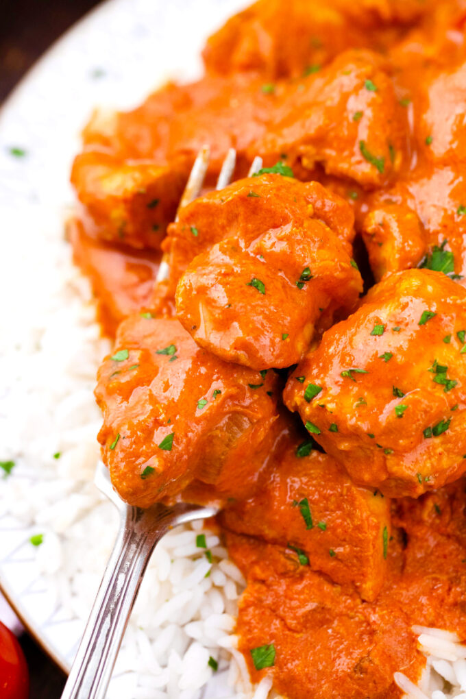 Close shot of a forkful of creamy slow cooker tikka masala.