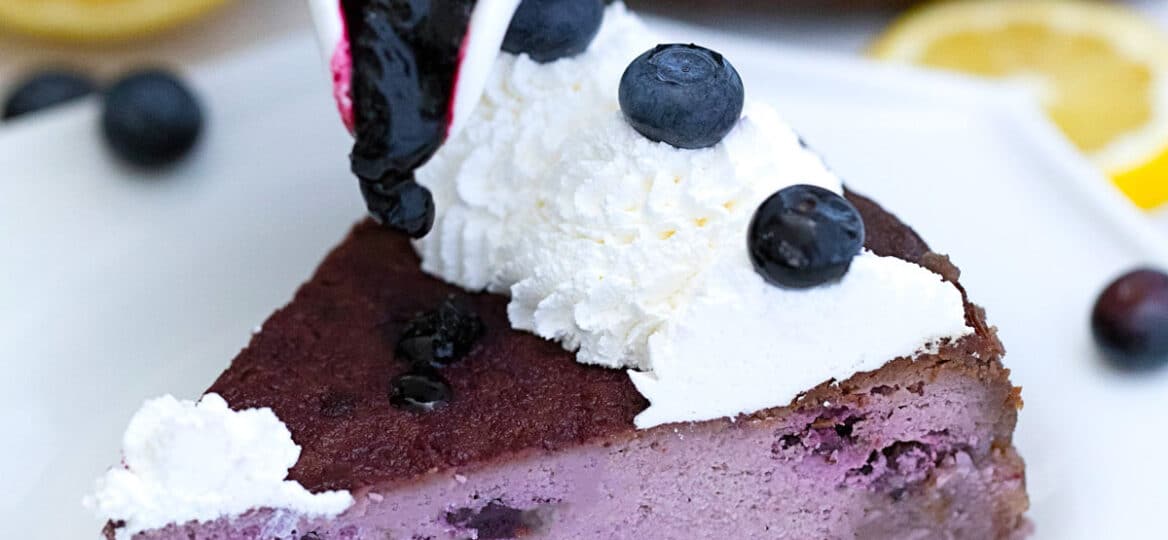 Photo of low carb blueberry cheesecake slice with blueberry sauce.