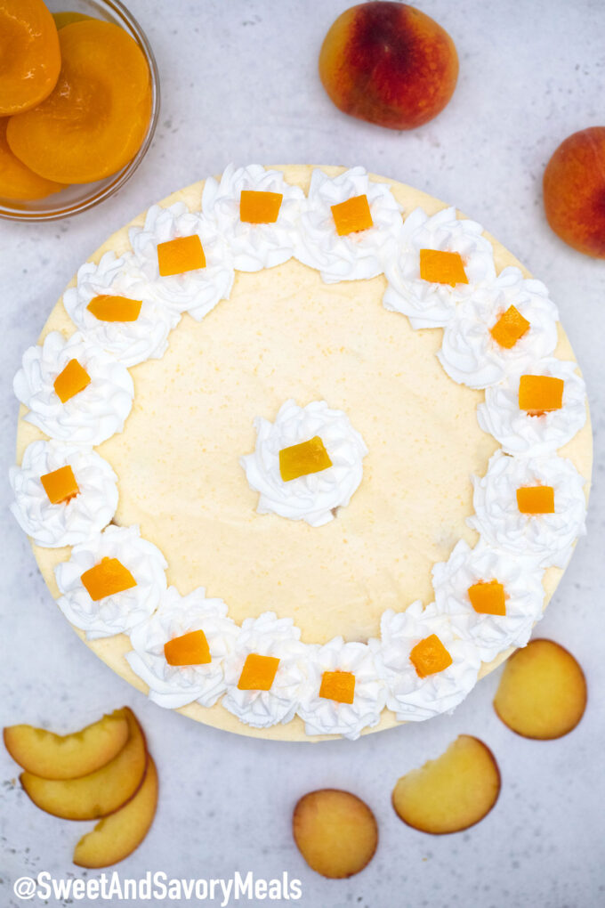 no bake peach cheesecake with canned and fresh peaches next to it