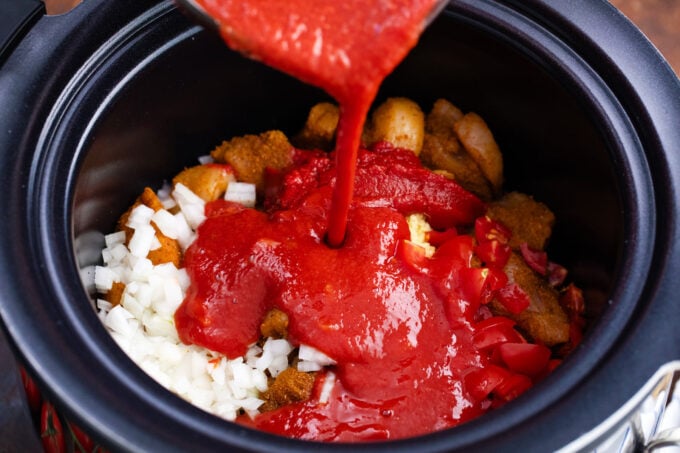 Adding slow cooker tikka masala ingredients to the crockpot.