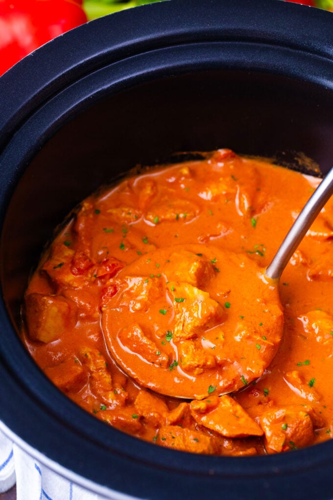 A ladle of creamy slow cooker tikka masala in the crockpot.