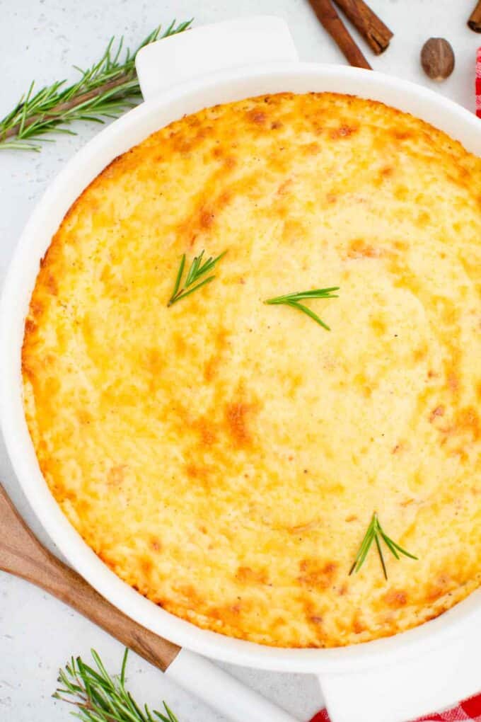 overhead shot of scalloped sweet potatoes casserole topped with rosemary