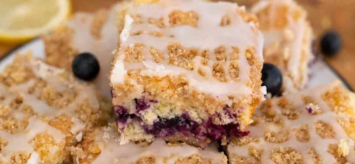 Blueberry buckle bars with fresh blueberries on a plate.