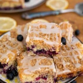 Blueberry buckle bars with fresh blueberries on a plate.
