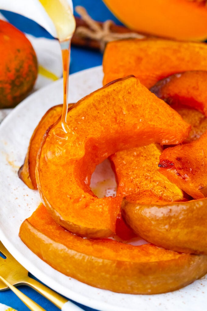 Drizzling honey over roasted pumpkin slices.