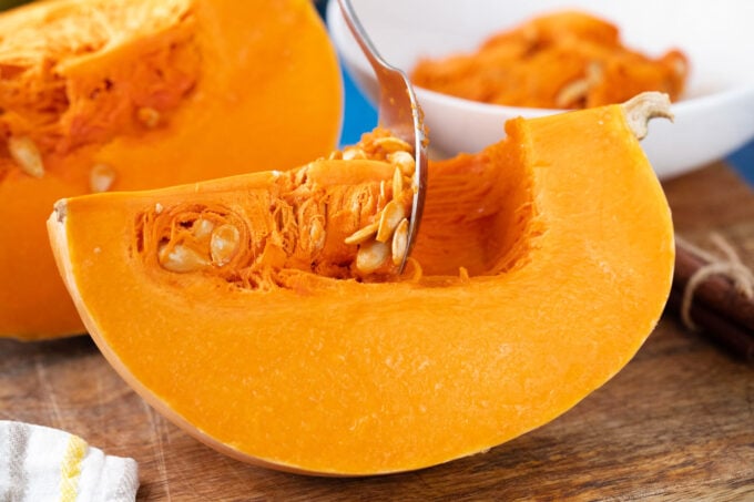 Scooping the flesh from a pumpkin.