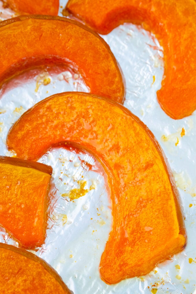 Homemade roasted pumpkin slices on a baking sheet.