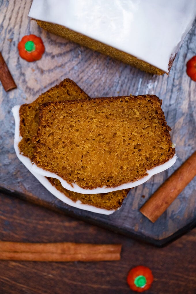 Overhead shot of moist slices of pumpkin bread with cream cheese frosting.