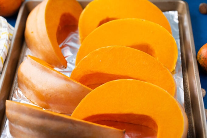 Sliced pumpkin on a baking sheet.