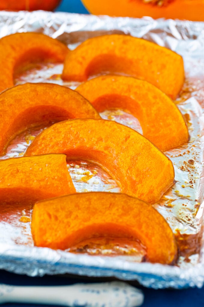 Perfectly roasted pumpkin slices arranged on a baking sheet.