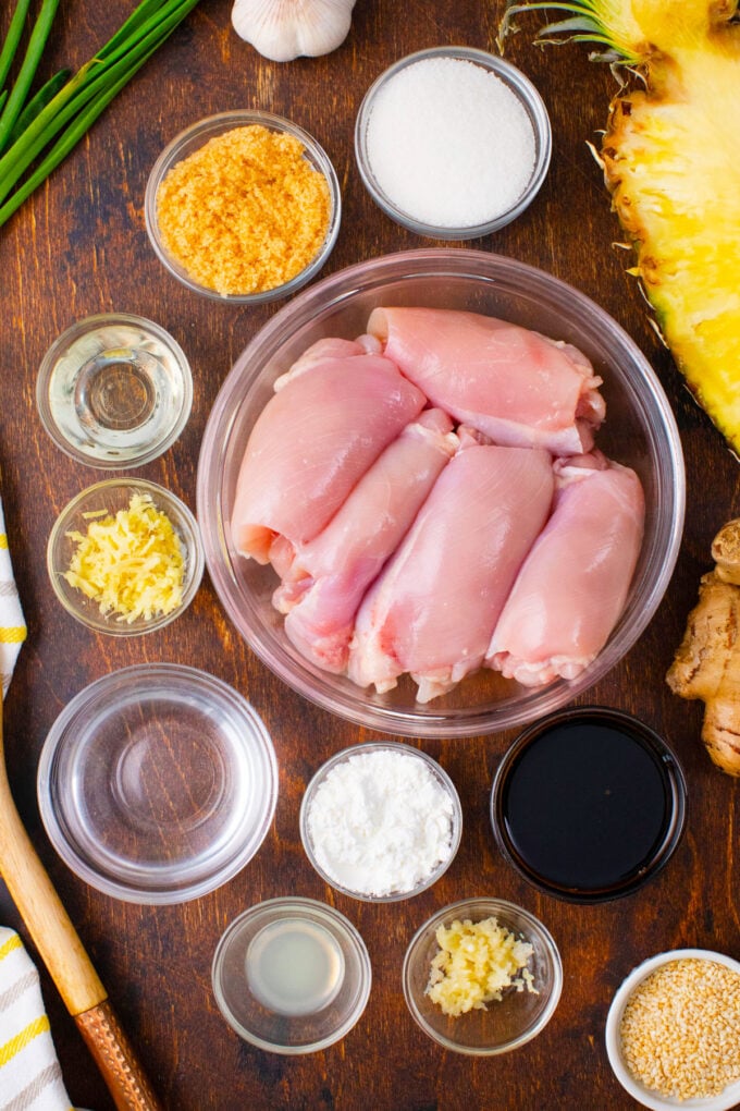 Overhead shot of Panda Express mandarin teriyaki chicken ingredients arranged in bowls on a wooden surface.