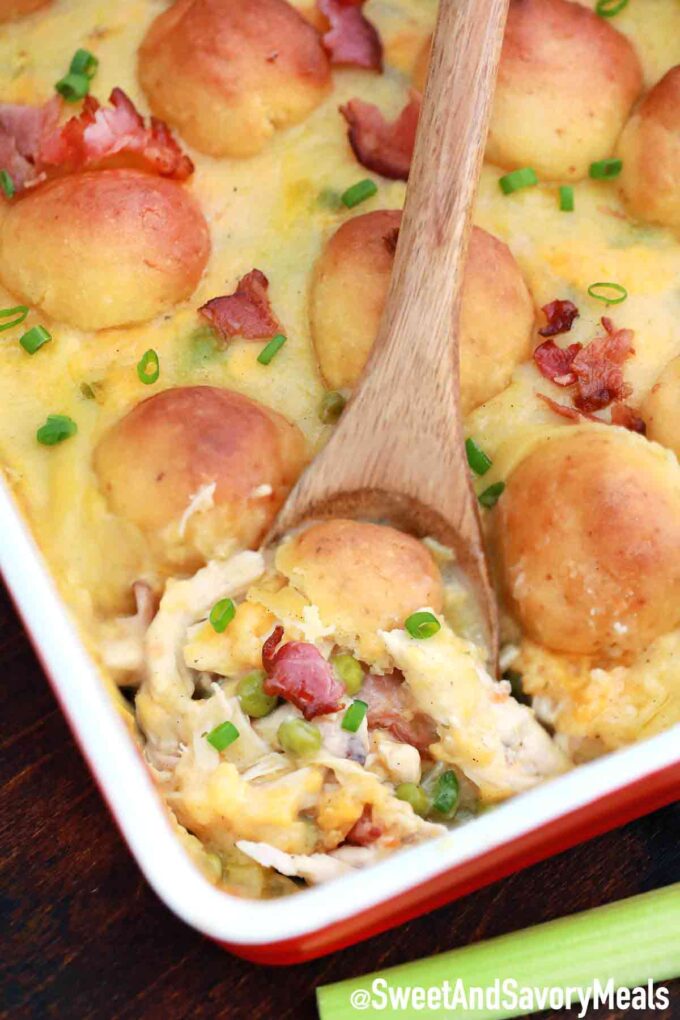 chicken and dumplings in a casserole dish and a wooden spoon.