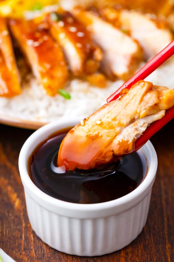 Dipping a piece of grilled chicken in Panda Express mandarin teriyaki sauce.