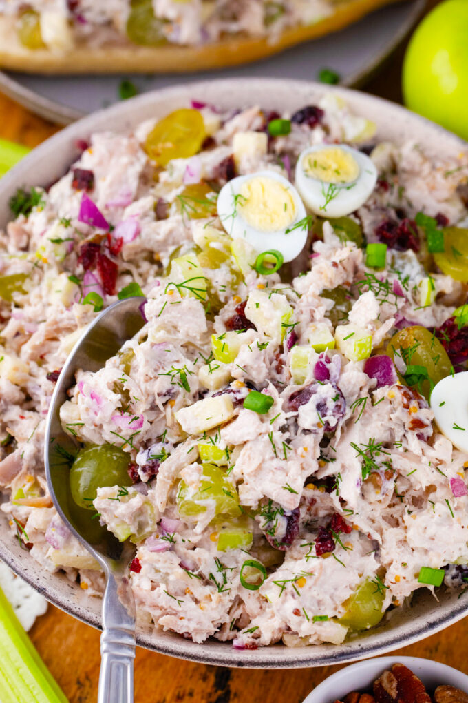 A bowl of turkey salad with grapes and quail eggs.